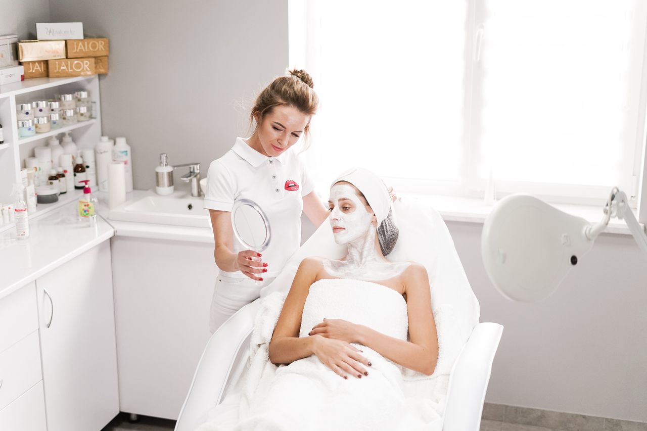 The Art of Drawing Readers In: Your attractive post title goes here Beautician applying a facial mask to a client in a modern salon. Professional skincare service indoors.