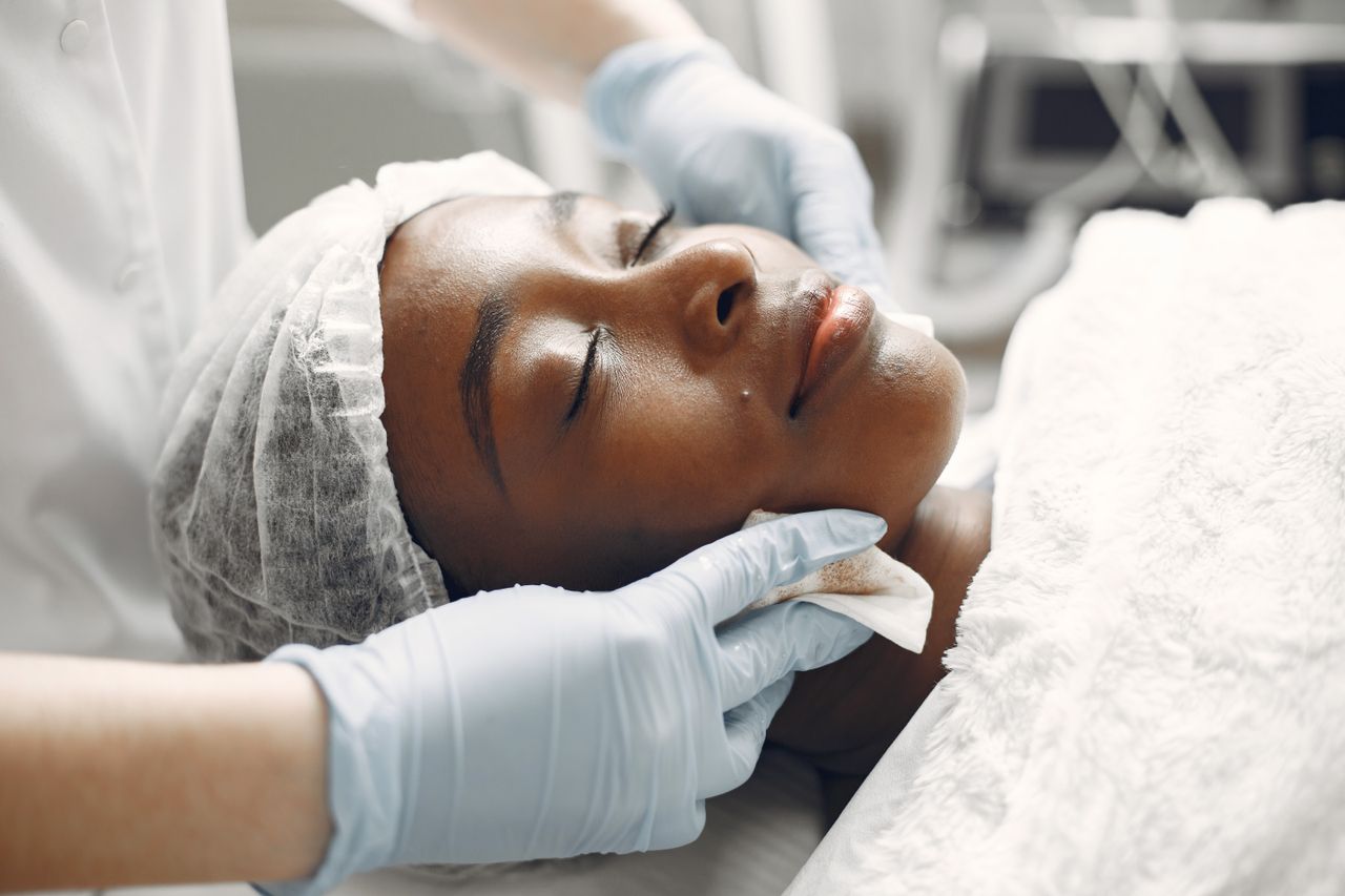 Services A woman enjoying a calming facial treatment at a spa, promoting relaxation and rejuvenation.